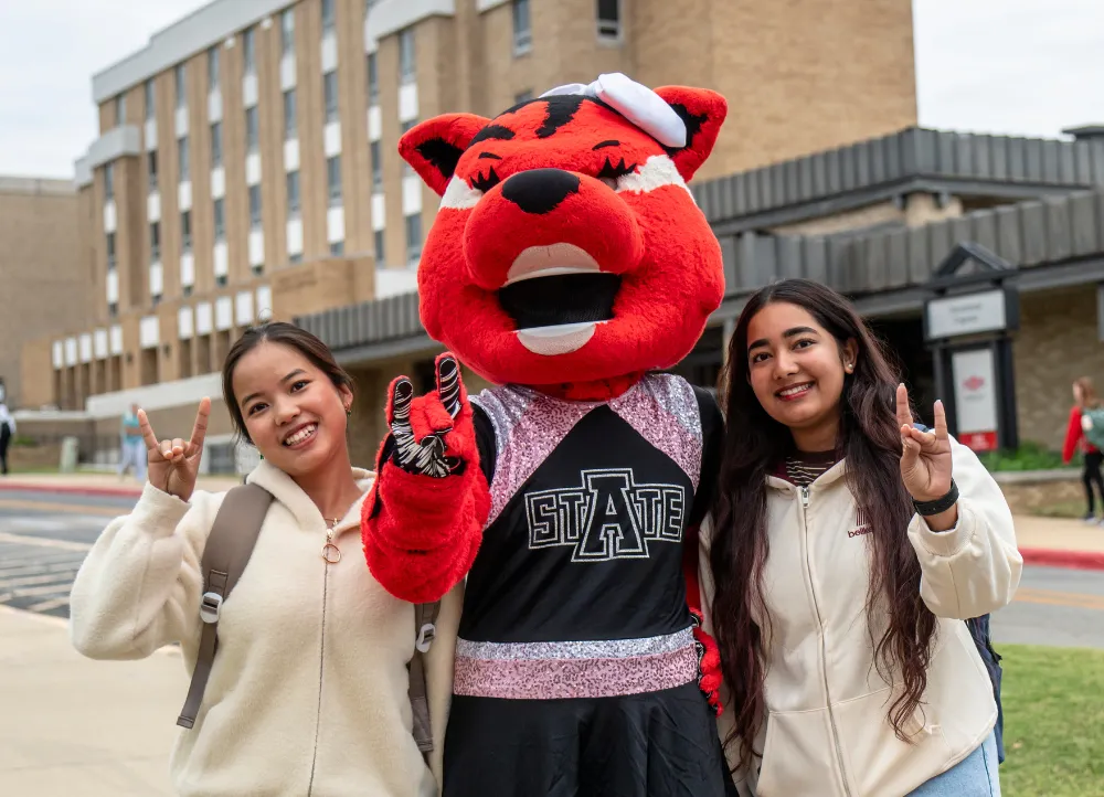 The Scarlett mascot on campus with two students.