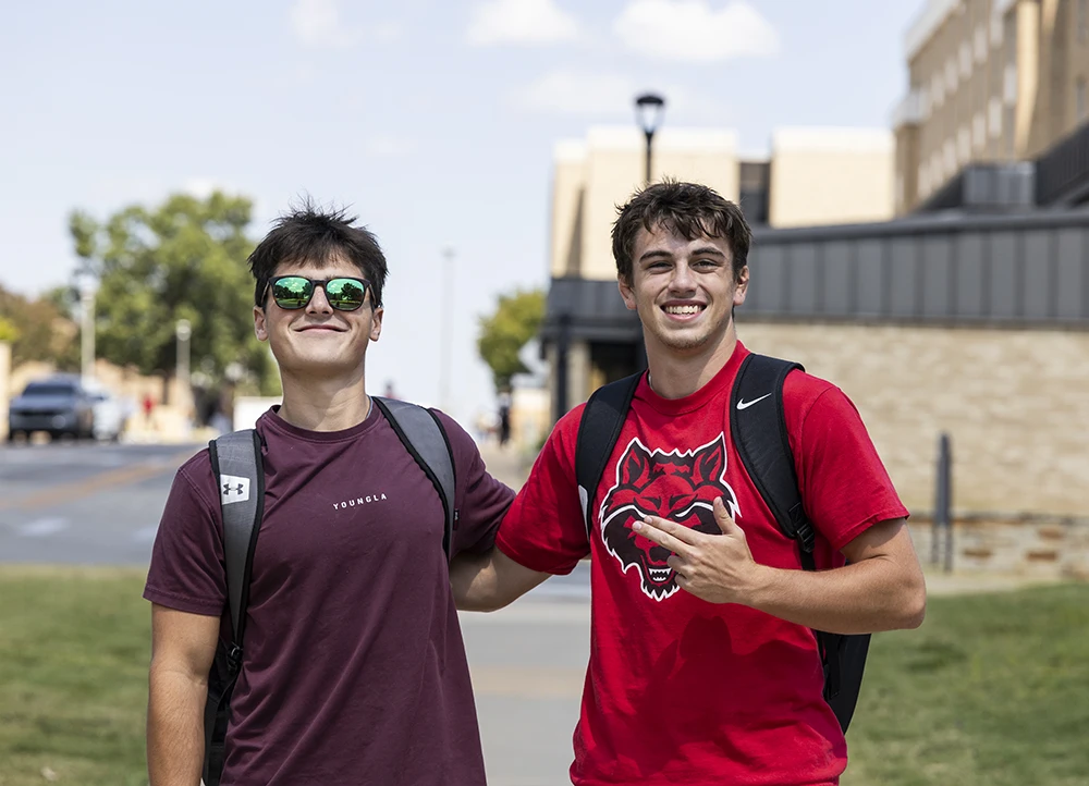 Two students in Red Wolves shirts posing.