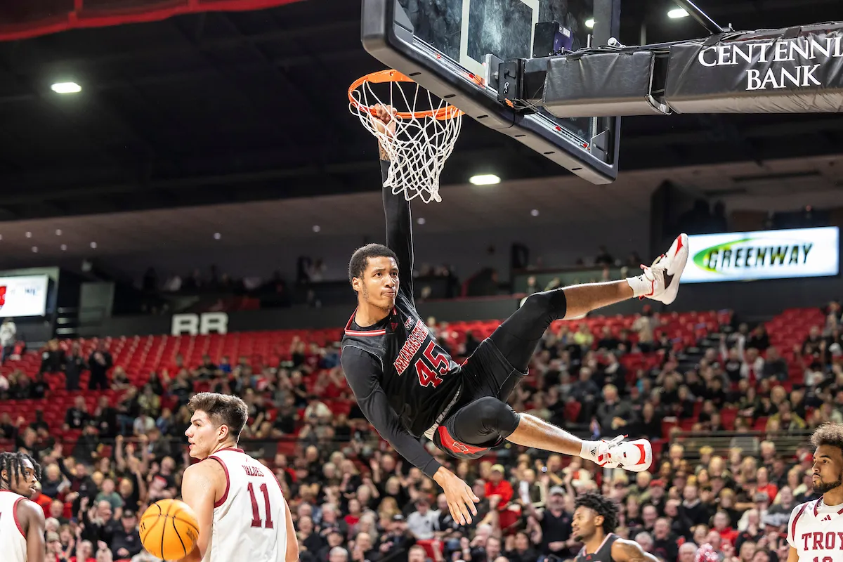 Red Wolves basketball player hanging from rim.