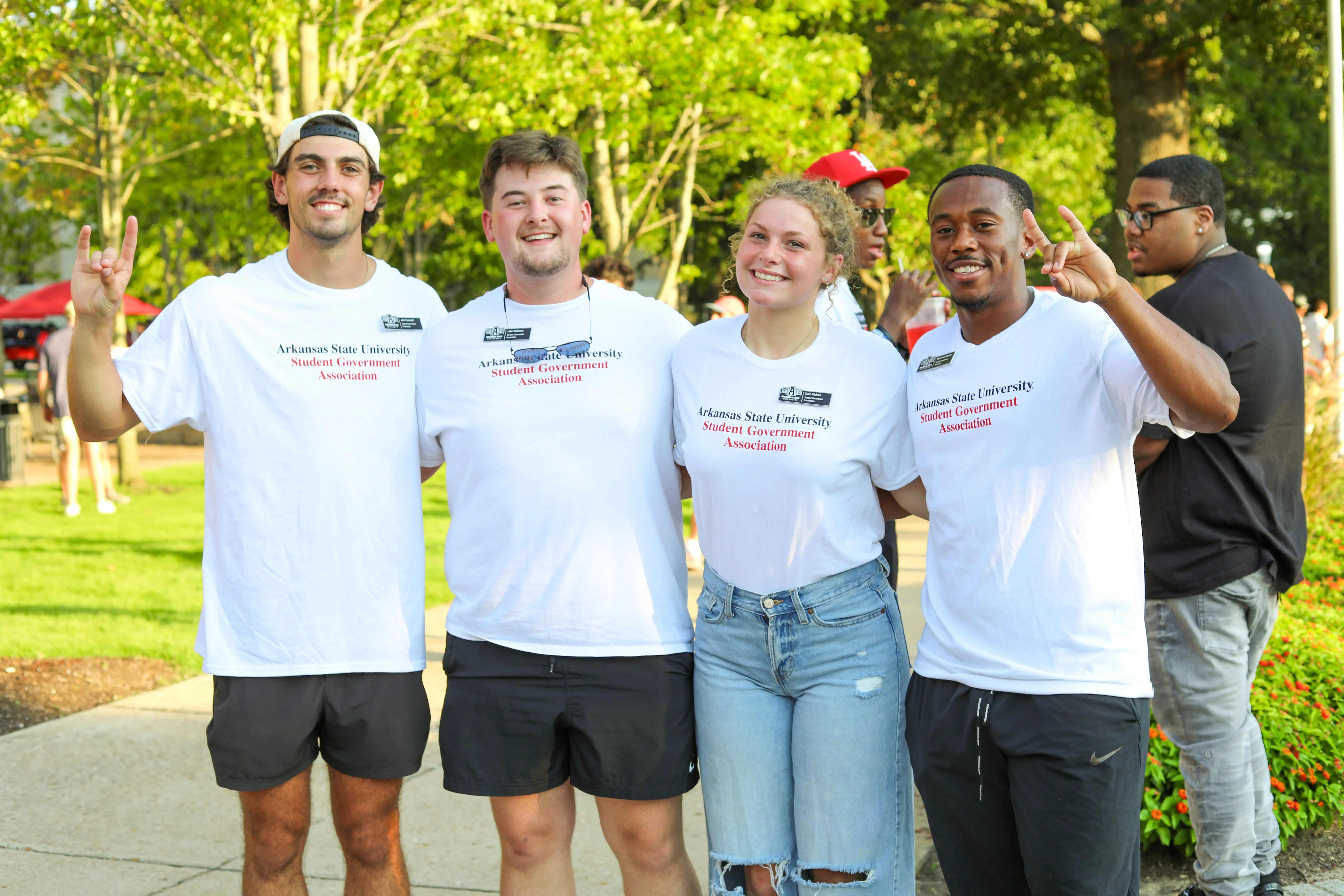 Students posing together with 'wolves up' hand motions.
