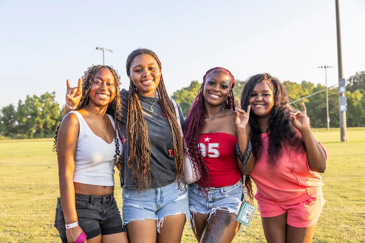 A group of girls pose with their wolves up on campus