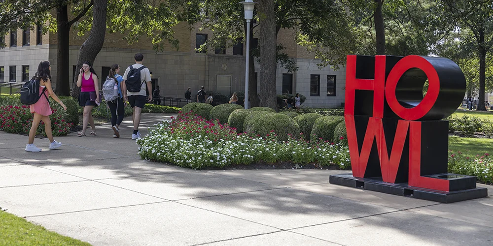 Students walking by the HOWL sculpture.
