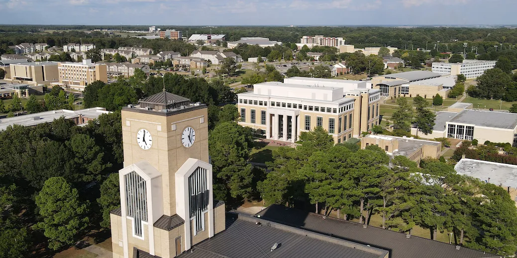 A drone shot of the A-State campus, highlighting the library clock tower and a sprawling campus