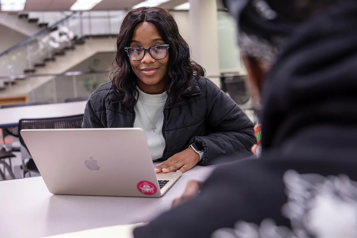 A student users her laptop in the Dean B Ellis Library