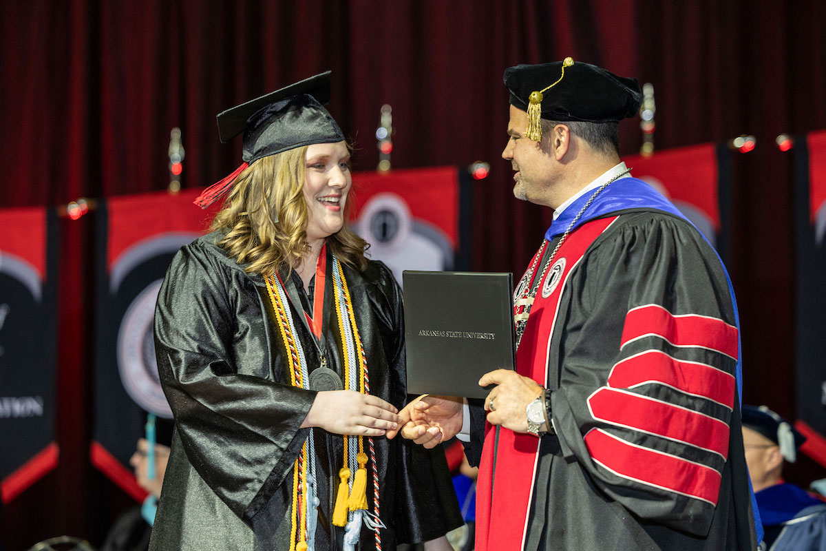 Chancellor Shields presents a diploma