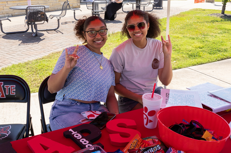 Students with their Wolves Up at a campus information booth