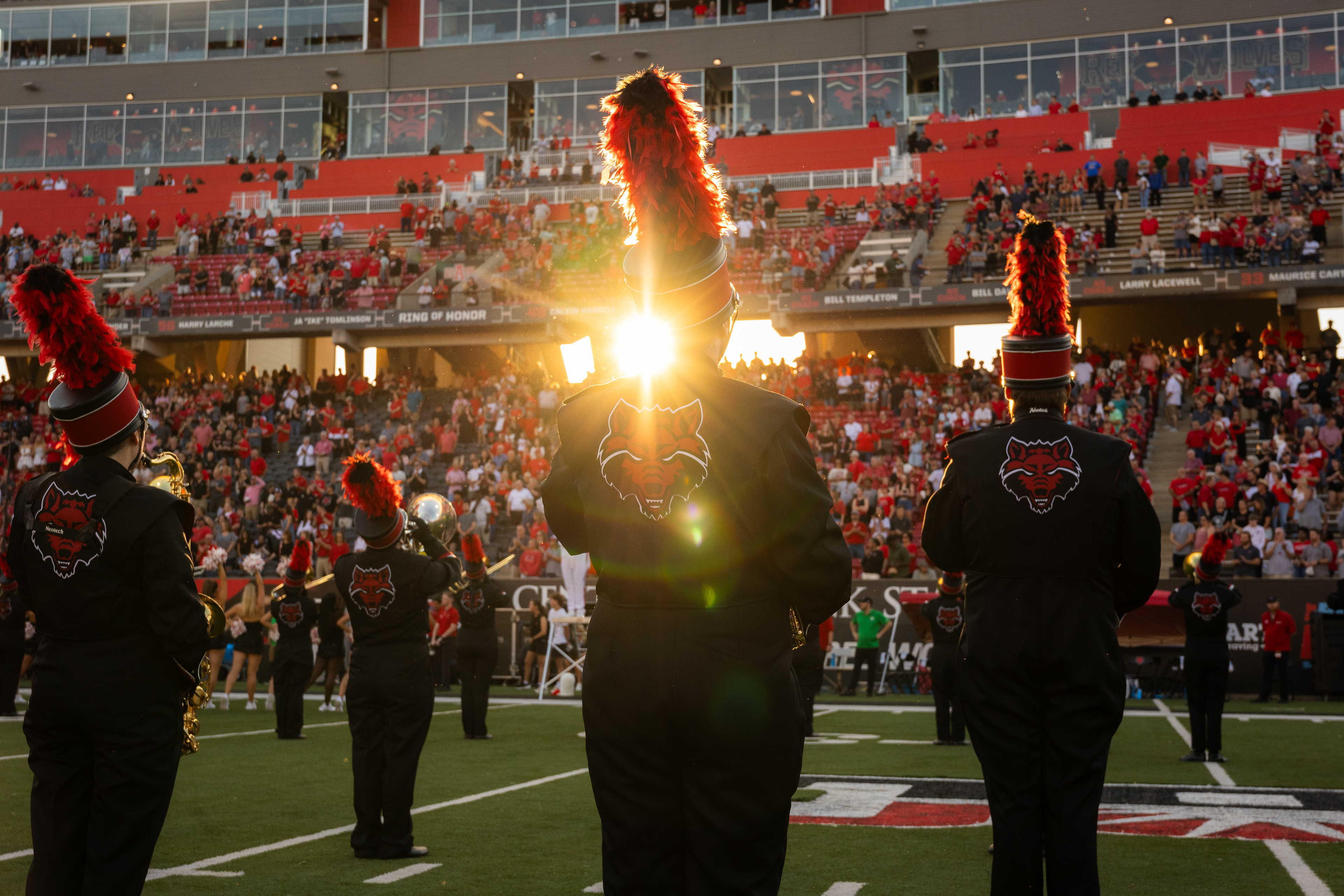 Marching Band performing in the stadium with the sun peaking through