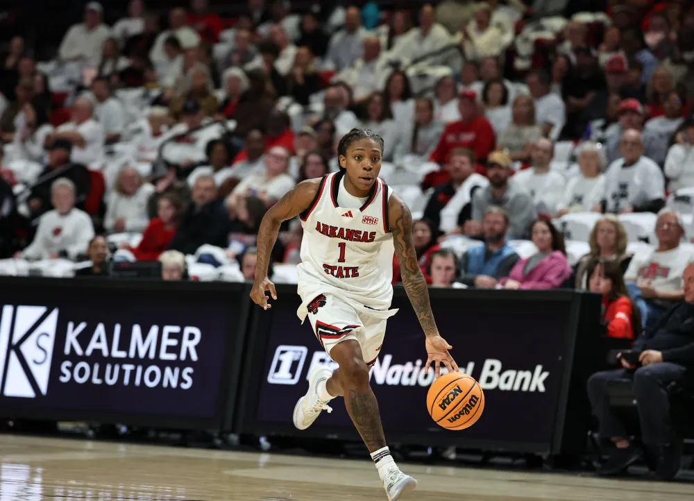 A-State basketball player driving the ball down court.