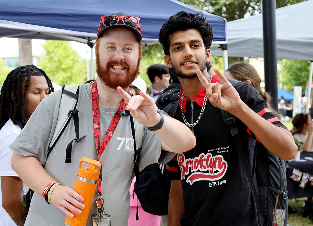 Two H.O.W.L. Transition Program Students giving Wolves Up.