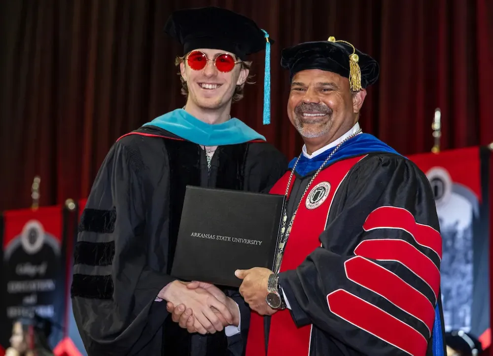 Chancellor Todd Shields awards a graduate degree at a recent commencement ceremony.