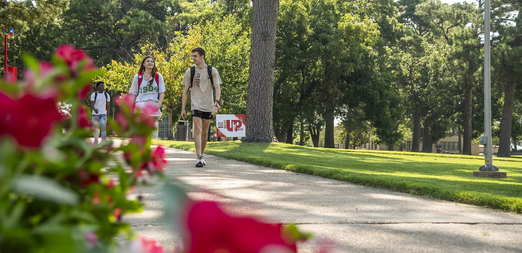 Two students walking by the HOWL sculpture.