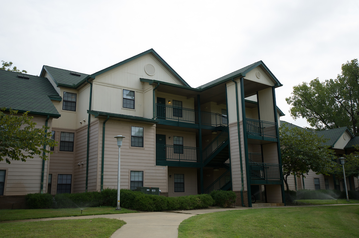 Exterior view of an A-State student housing building with green roof and outdoor staircases.