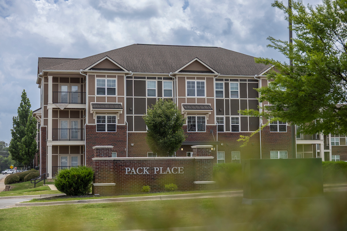 Pack Place student housing at A-State with brick and tan siding under a cloudy sky.