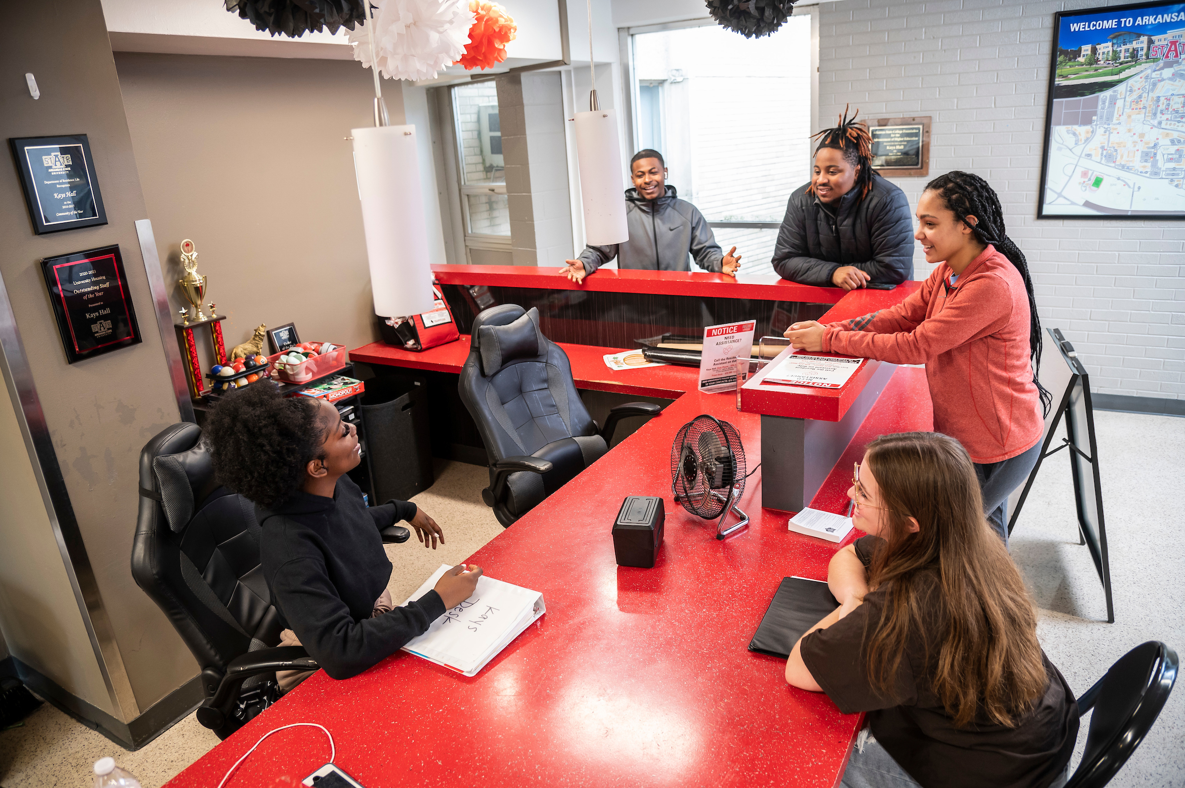 Students chat and study around a red counter in the Kay’s Hall lobby at Arkansas State University.