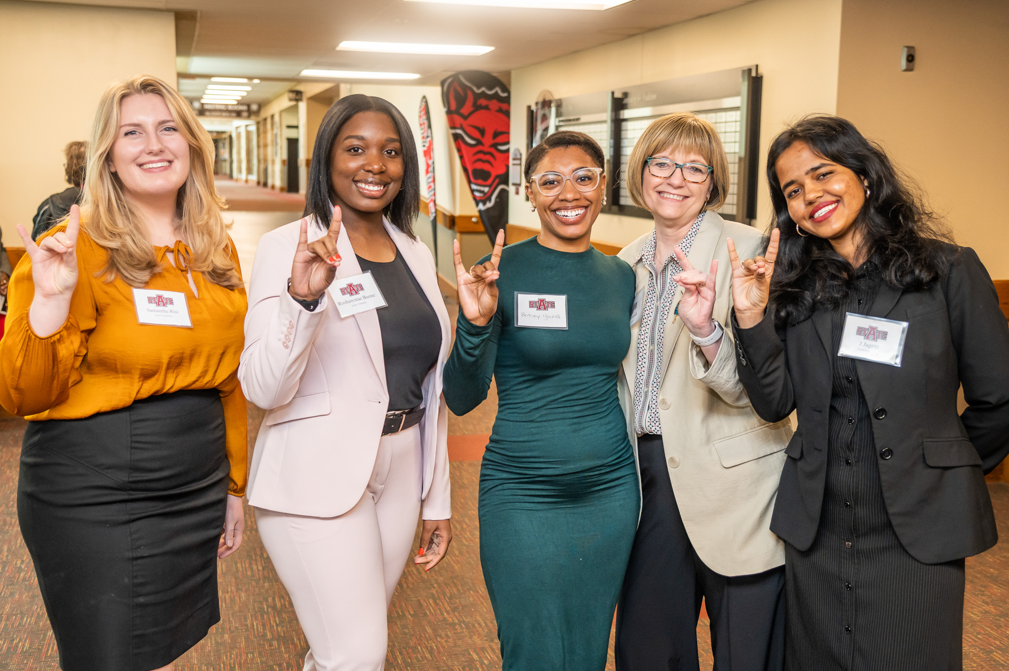 Students and mentors pose in hallway at annual Women's Conference event.