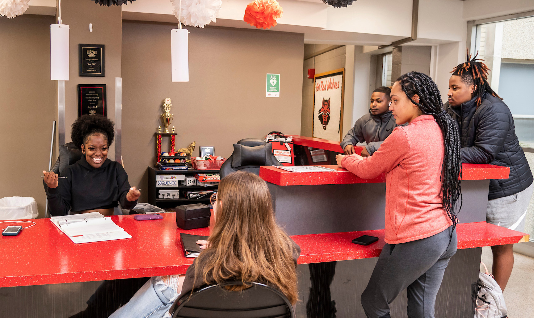 Students chat and study around a red counter in the Kay’s Hall lobby at Arkansas State University.