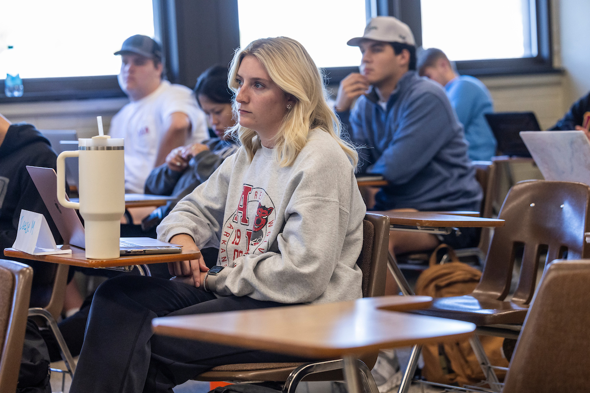 A student sitting at a desk and looking toward the teacher.